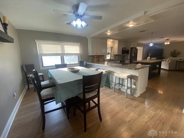 dining room featuring baseboards, ceiling fan, and wood finished floors