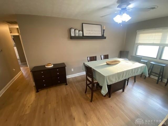 dining room featuring wood finished floors, baseboards, and ceiling fan