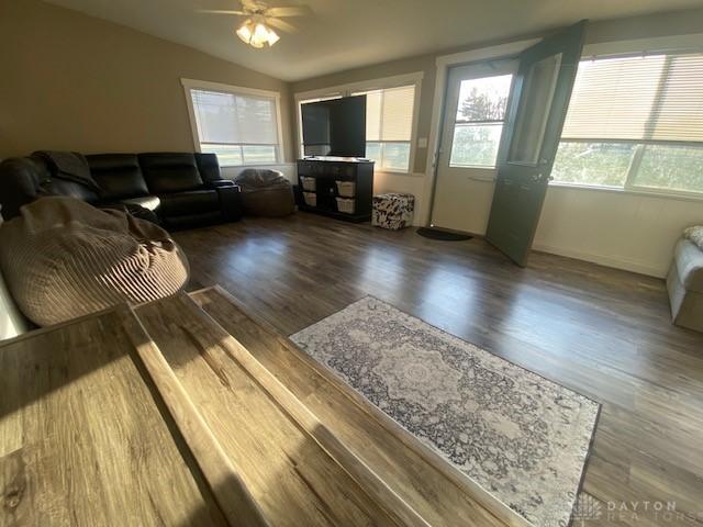 living area with ceiling fan, lofted ceiling, and wood finished floors