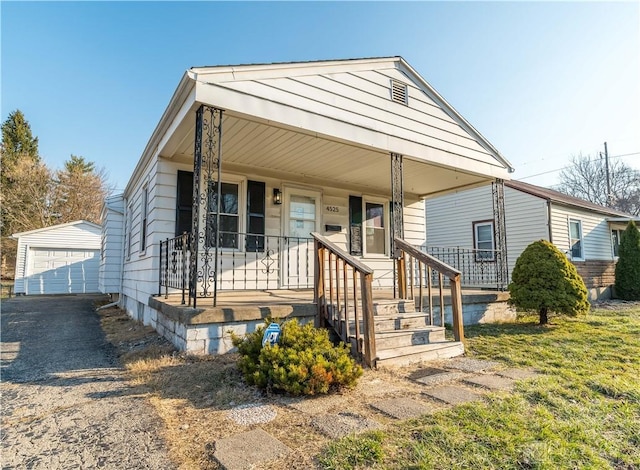 view of front of home with a garage, a porch, and an outdoor structure