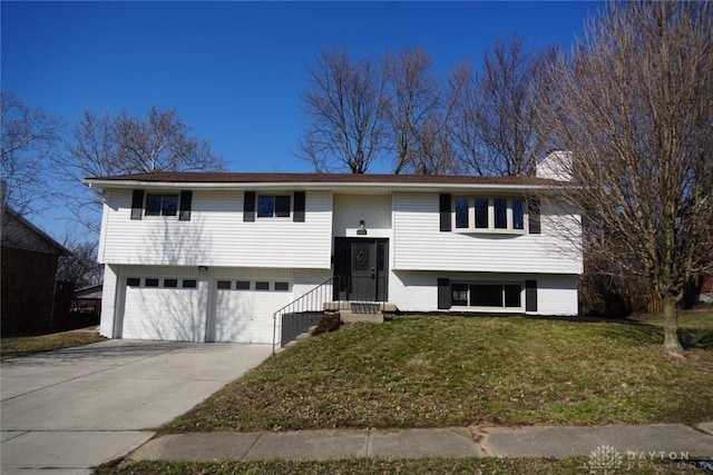 bi-level home featuring brick siding, a front lawn, concrete driveway, a chimney, and an attached garage