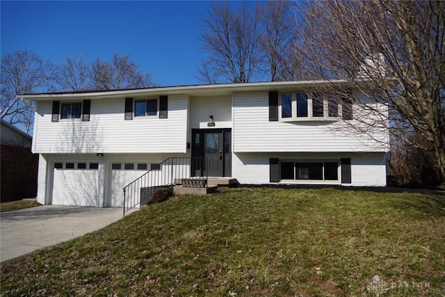 raised ranch featuring a front yard, a garage, brick siding, and driveway