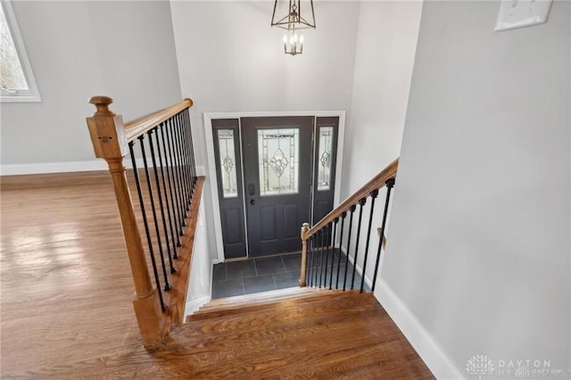 entryway featuring an inviting chandelier, wood finished floors, and baseboards