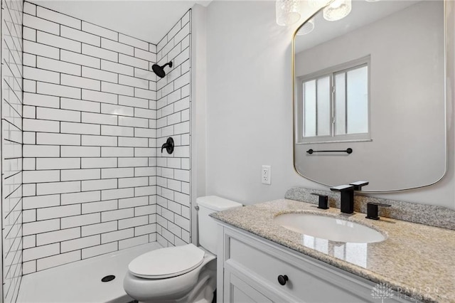 bathroom with a shower stall, toilet, and vanity