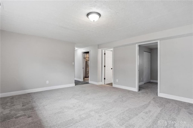 unfurnished bedroom featuring a closet, baseboards, carpet, and a textured ceiling