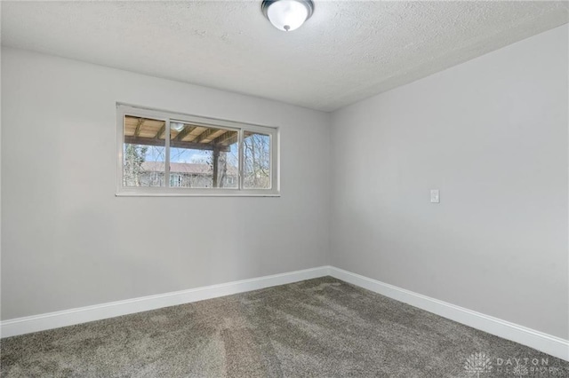 carpeted empty room with a textured ceiling and baseboards