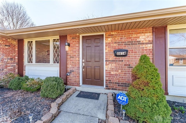 view of exterior entry featuring brick siding