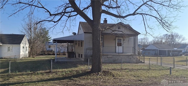 view of front of property with a fenced front yard, covered porch, and a chimney