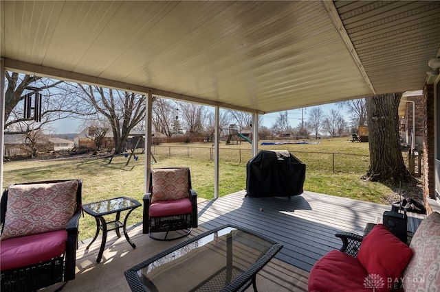 deck featuring fence, a lawn, a grill, and a playground