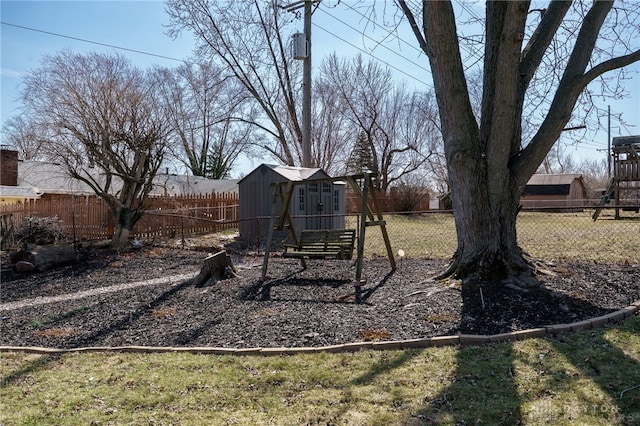 view of yard with an outdoor structure, a fenced backyard, and a shed