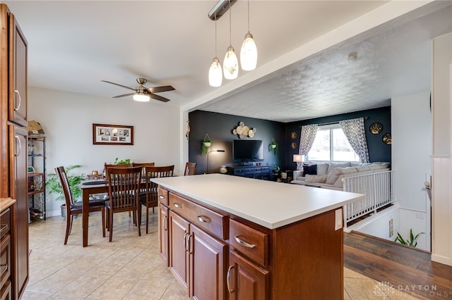 kitchen with brown cabinets, a kitchen island, open floor plan, light countertops, and hanging light fixtures