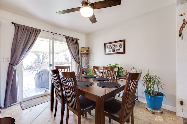 dining room with light tile patterned floors, baseboards, and a ceiling fan