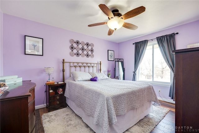 bedroom featuring wood finished floors, baseboards, and ceiling fan