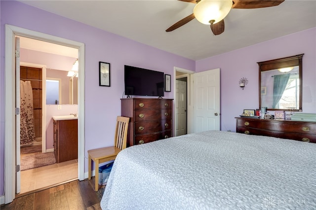 bedroom with ensuite bath, wood finished floors, and ceiling fan