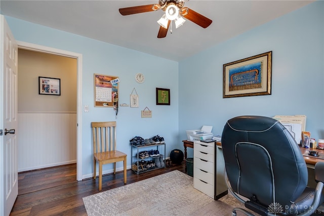 office space with a ceiling fan, wood finished floors, and a wainscoted wall