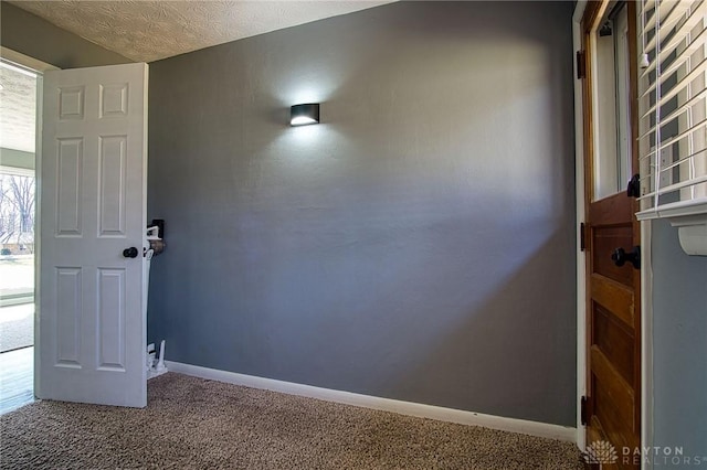 empty room with baseboards, a textured ceiling, and carpet flooring