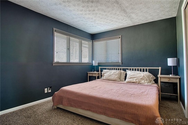 carpeted bedroom featuring baseboards and a textured ceiling