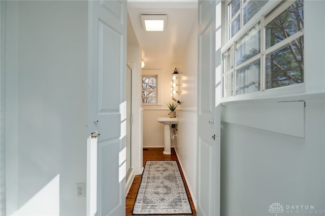 hallway with a wainscoted wall and dark wood-style flooring