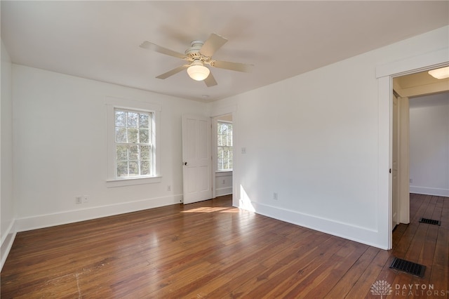 spare room featuring a ceiling fan, baseboards, visible vents, and wood-type flooring