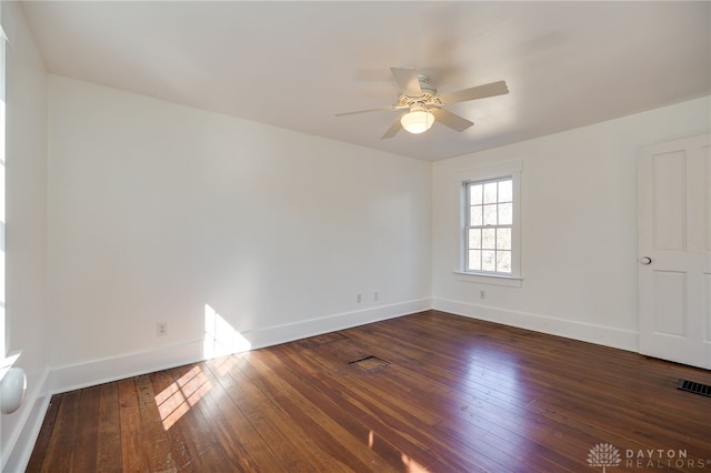 spare room with visible vents, baseboards, dark wood finished floors, and a ceiling fan