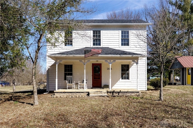 view of front facade with covered porch, a front yard, and a shingled roof