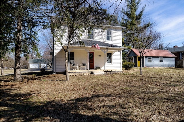 view of front of home featuring a porch, a front lawn, and an outdoor structure