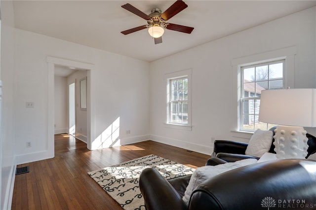 living area with a wealth of natural light, visible vents, baseboards, and hardwood / wood-style floors