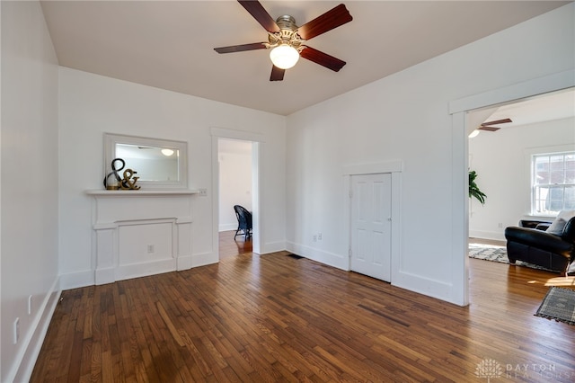 unfurnished living room with hardwood / wood-style floors, a ceiling fan, and baseboards