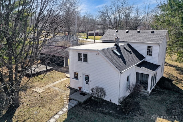 back of house with a shingled roof