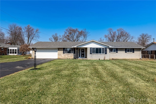 ranch-style house with a front lawn, an attached garage, and driveway