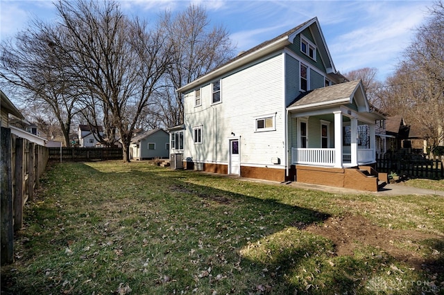 back of property featuring a porch, fence private yard, and a yard