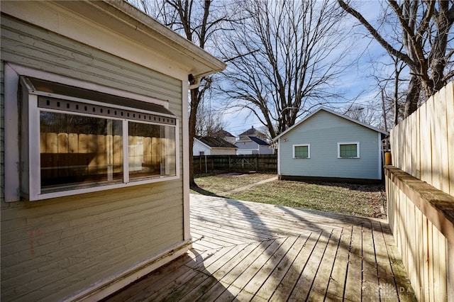 wooden terrace featuring an outbuilding and a fenced backyard