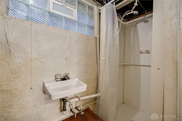 full bath with a shower with shower curtain and a sink