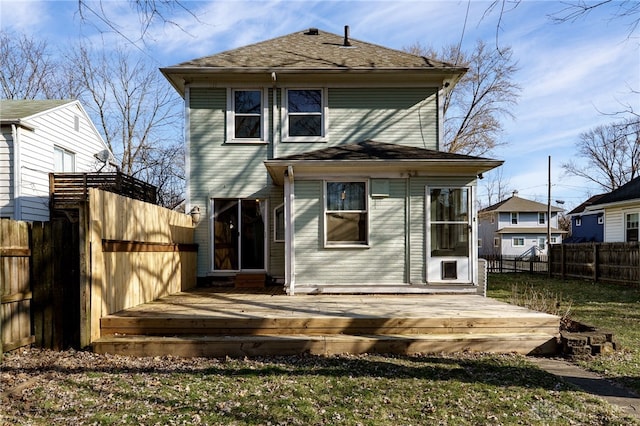 back of property with a fenced backyard and a deck