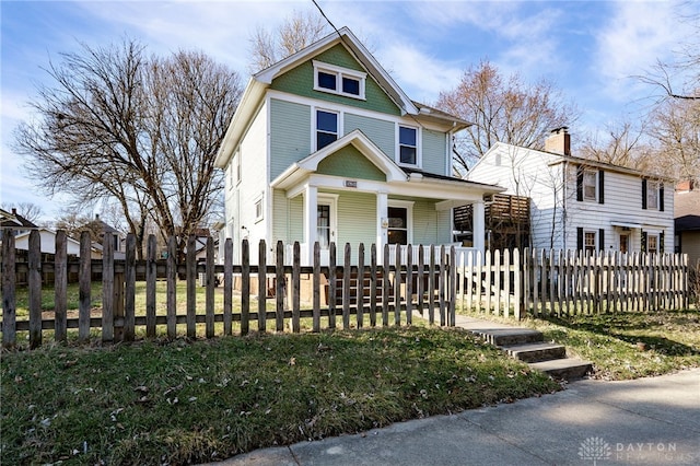 view of front of property with a fenced front yard and a porch