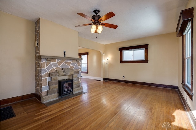 unfurnished living room with visible vents, baseboards, ceiling fan, and hardwood / wood-style flooring