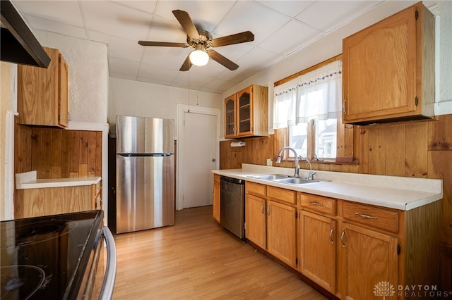 kitchen with ceiling fan, a sink, light countertops, appliances with stainless steel finishes, and light wood-type flooring