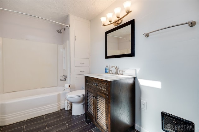 bathroom featuring wood finish floors, toilet, a textured ceiling, shower / bathing tub combination, and vanity