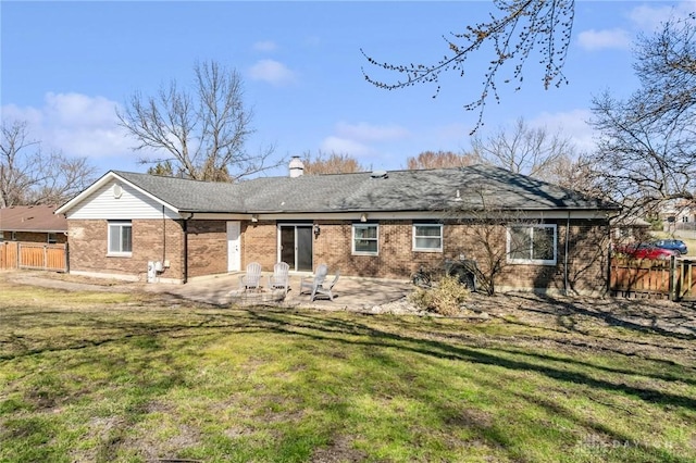 back of house featuring a patio area, brick siding, a yard, and fence