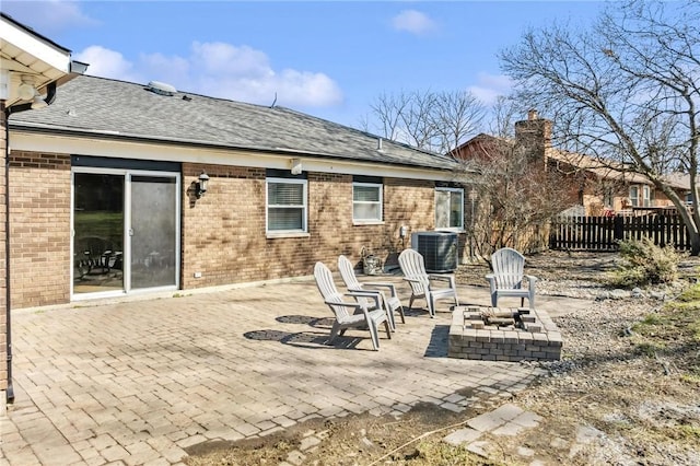 back of property with fence, cooling unit, brick siding, a chimney, and a patio area