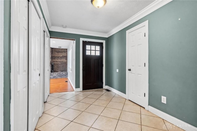 entrance foyer with light tile patterned floors, baseboards, and crown molding