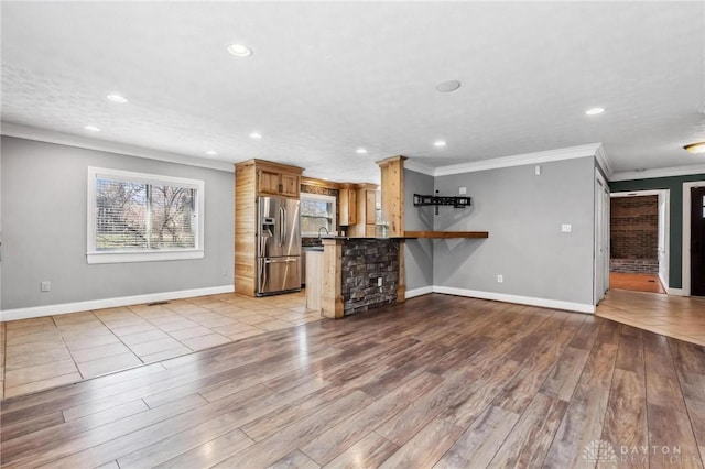 unfurnished living room featuring crown molding, recessed lighting, wood finished floors, and baseboards