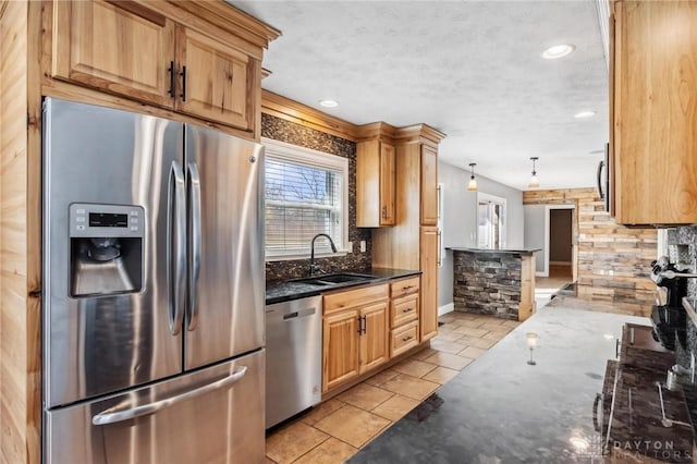 kitchen with dark stone countertops, a sink, stainless steel appliances, a textured ceiling, and backsplash