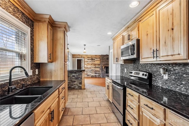 kitchen featuring backsplash, light brown cabinetry, light tile patterned floors, appliances with stainless steel finishes, and a sink