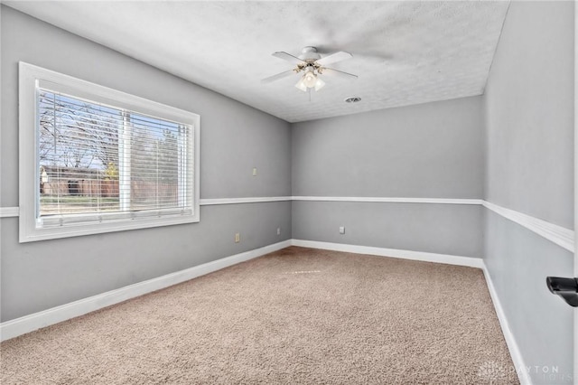 carpeted empty room with baseboards and ceiling fan