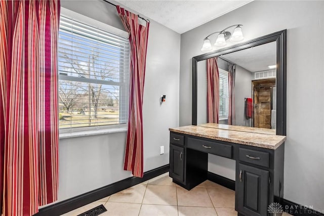 bathroom with tile patterned floors, plenty of natural light, vanity, and baseboards