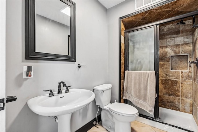 bathroom with tile patterned flooring, toilet, and a stall shower