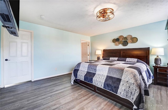 bedroom featuring wood finished floors and baseboards