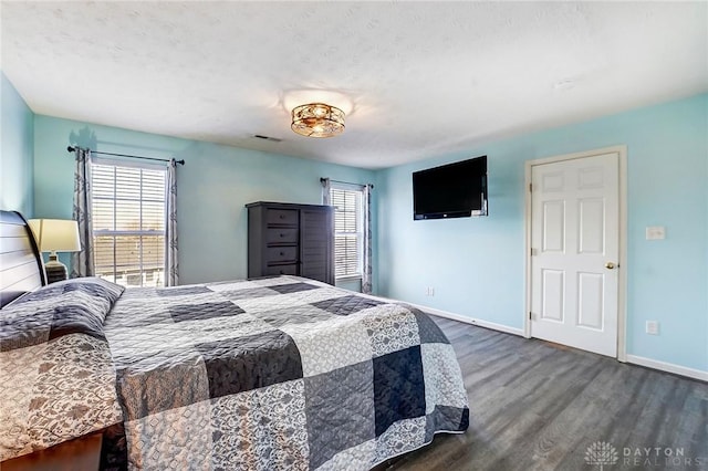 bedroom featuring visible vents, baseboards, and wood finished floors