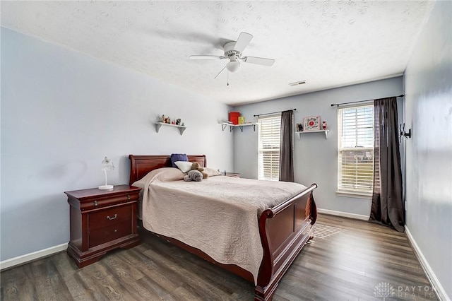 bedroom with visible vents, a ceiling fan, a textured ceiling, dark wood-style floors, and baseboards